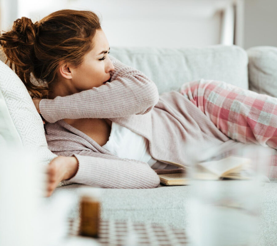 young-woman-coughing-into-elbow-while-lying-down-on-sofa-in-the-living-room (2) young-woman-coughing-into-elbow-while-lying-down-on-sofa-in-the-living-room (2)